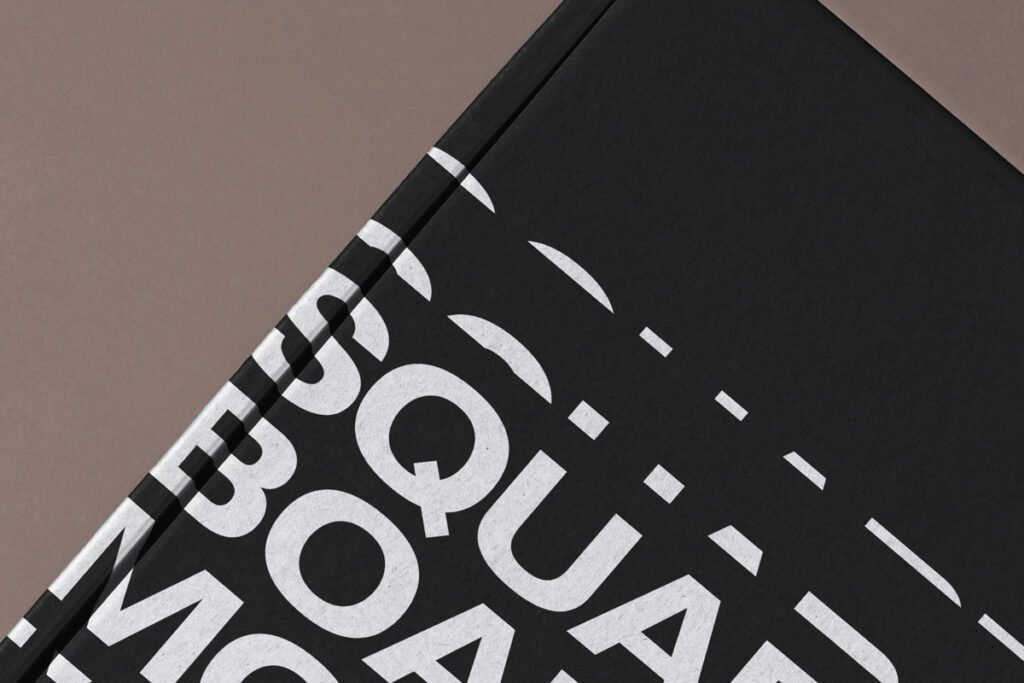 Close-up of a black cardboard mailer box with abstract white typography.