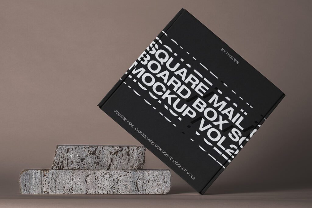 Black square mailer box mockup with white typography leaning on two rustic stone blocks.