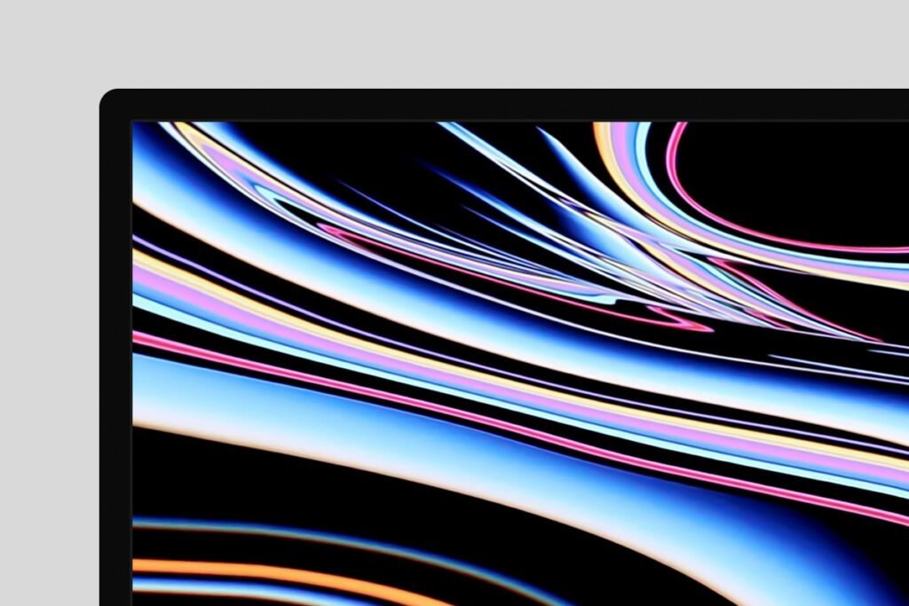 Close-up of a modern computer monitor screen displaying an abstract colorful wallpaper with flowing blue, pink, and white lines on a black background.
