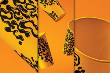 Multiple yellow Falling PSD Paper Cup Mockup with black abstract drip patterns appearing to fall or float against a vibrant orange background.