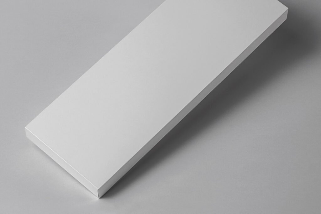 A sleek, minimalist long white packaging box mockup resting on a light gray surface, with subtle shadows.