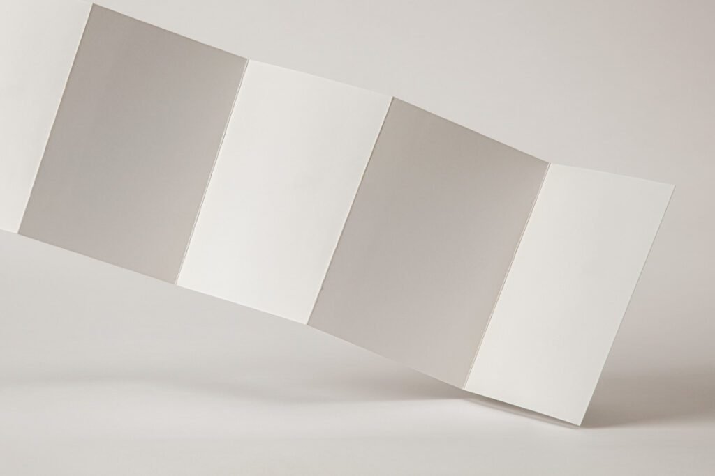 Blank realistic Z-fold brochure mockup floating or leaning on a white surface, showing multiple panels.
