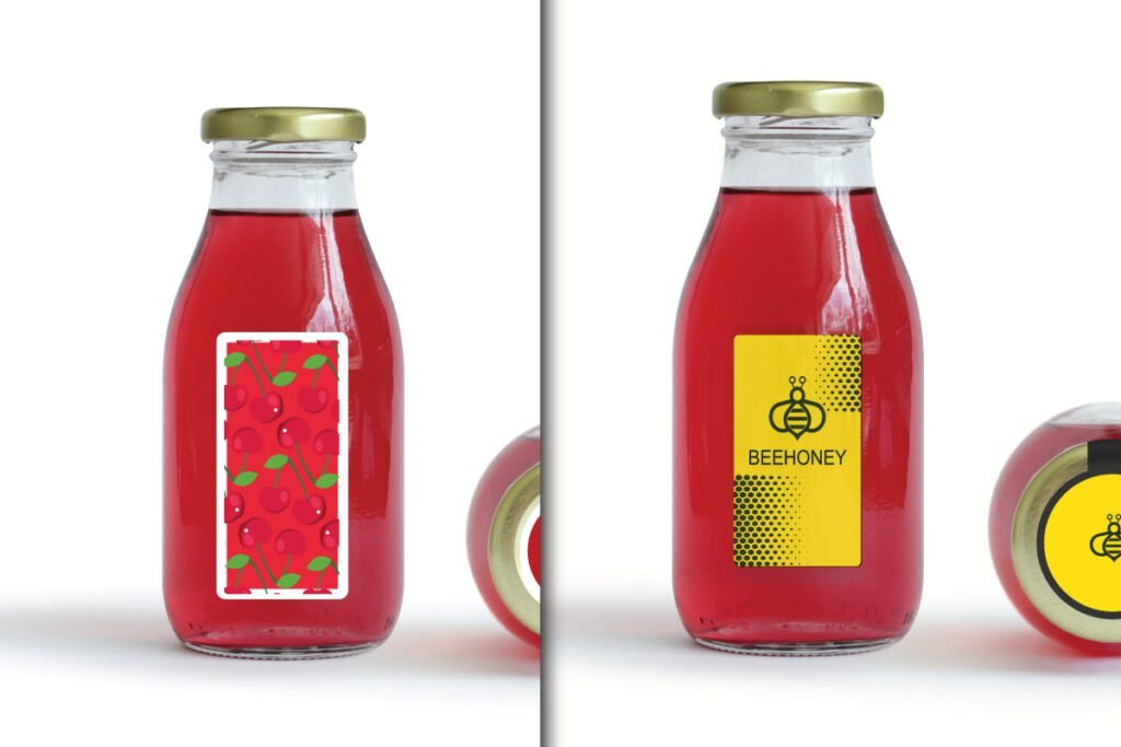 Juice and Honey Glass Bottle Label Mockup PSD showing two glass bottles with red liquid and gold caps. One has a white label with red cherries, and the other has a yellow Beehoney label.