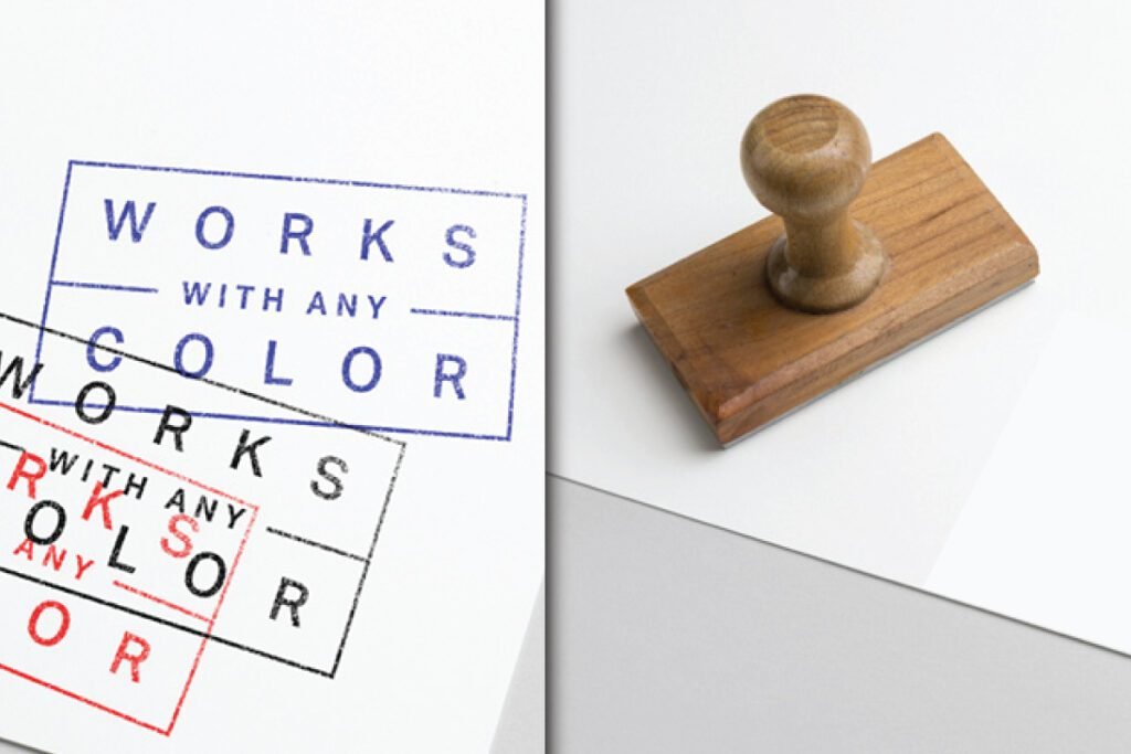 Best Rubber Stamp Mockup PSD on White Texture, featuring a wooden rubber stamp on the right and a white paper on the left displaying three stamp impressions in blue, black, and red that read Works With Any Color.