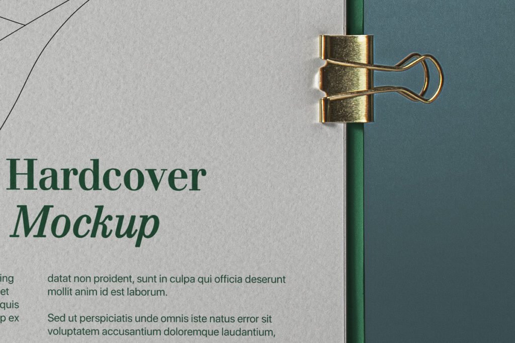 A close-up of a Square PSD Catalog showcasing a "Hardcover Mockup" title in green text on a light grey page, secured by a gold binder clip to a dark green spine.