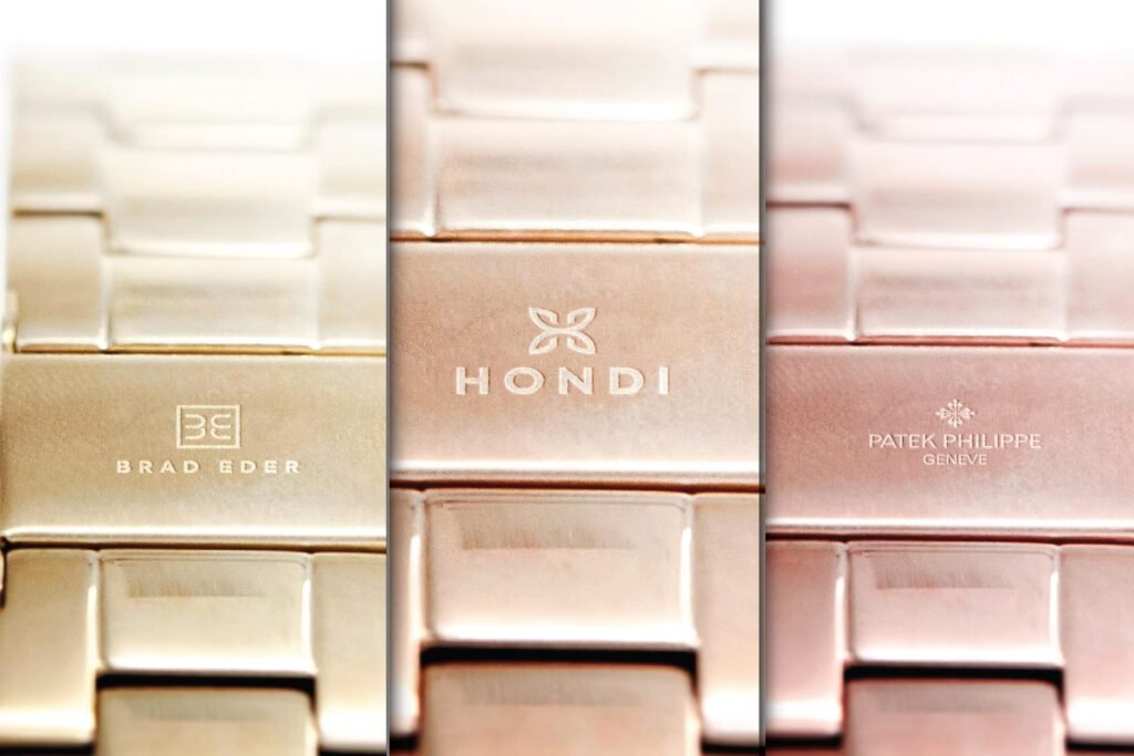 A close-up triptych of three watch clasps displaying different engraved logos. The left clasp is gold with "BE BRAD EDER," the middle is rose gold with a "HONDI" logo, and the right is rose gold with the Patek Philippe logo, all serving as a Watch Logo Mockup.