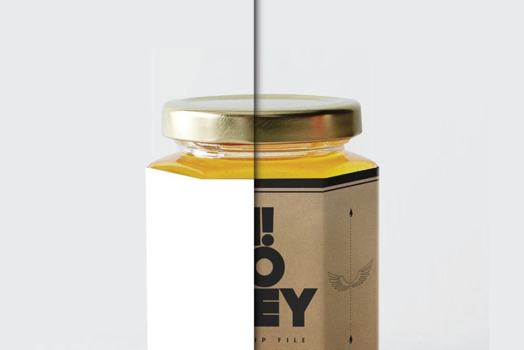 A close-up, split view of a Honey Jar Mockup. On the right, a jar with a gold lid and a kraft paper-colored label featuring black text and a small wing illustration is visible. The left side shows a plain white area, partially obscuring the label.