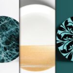 Best Realistic Ceramic Plate Wrap Mockup PSD displays three round plates with different designs: a blue marble pattern, a white and gold textured pattern, and a black floral pattern on a teal background.