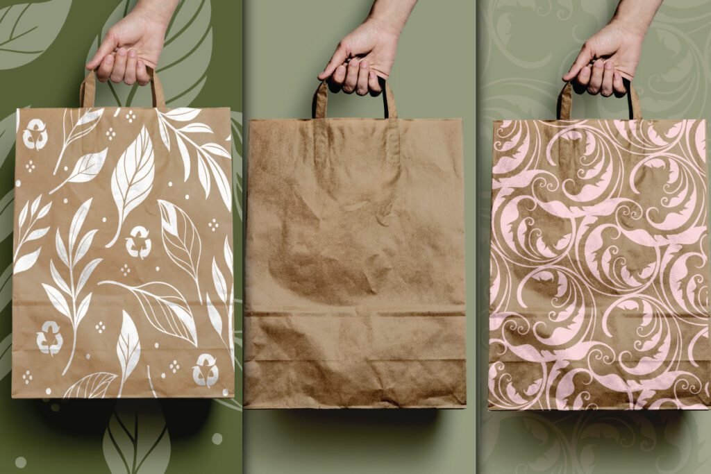 Best Zero Waste Eco Paper Bag Mockup PSD displays three hands holding brown paper bags. One bag has a white leaf pattern with recycle symbols. The middle bag is plain. The third bag has a light pink ornate pattern.